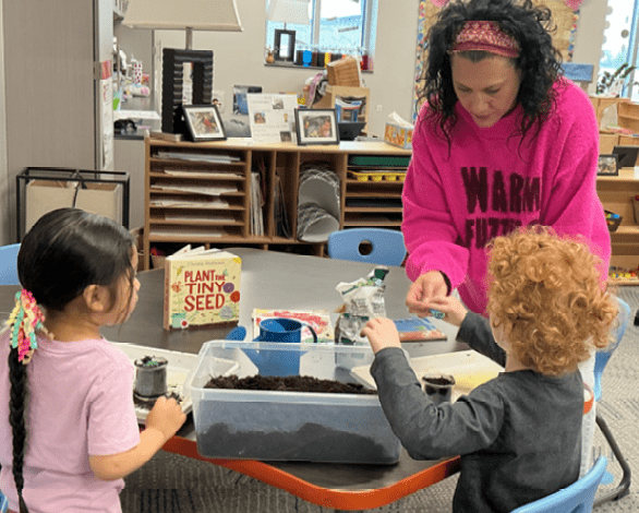Teacher apprentice Lindsay Schurman May Spotlight working with two students planting seeds